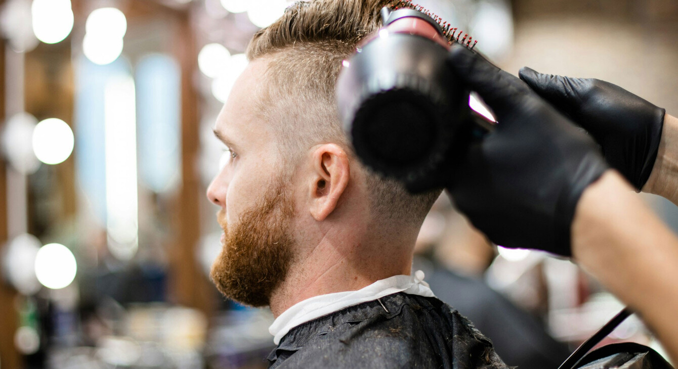 un homme se fait couper les cheveux dans un salon de coiffure