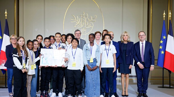 Des élèves posant à l'Élysée avec le prix reçu pour leurs affiches, en compagnie de Brigitte Macron, de membres du gouvernement, et de Monsieur Olivier Dugrip, recteur de l'académie de Lyon.